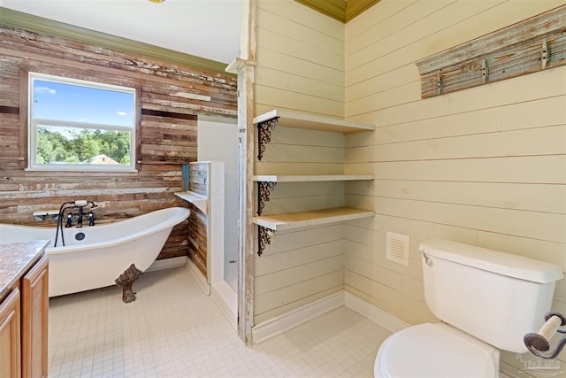 bathroom featuring tile patterned floors, toilet, wood walls, vanity, and a bathtub