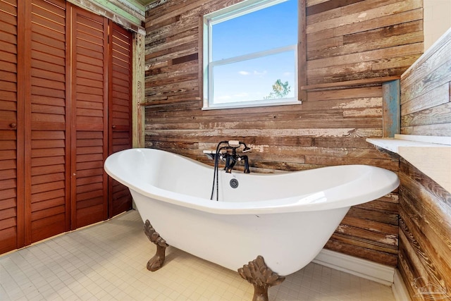 bathroom featuring a bath and wood walls