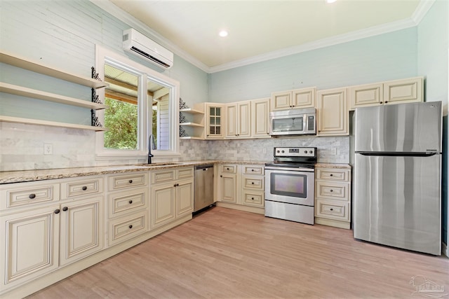 kitchen featuring appliances with stainless steel finishes, sink, an AC wall unit, and cream cabinets