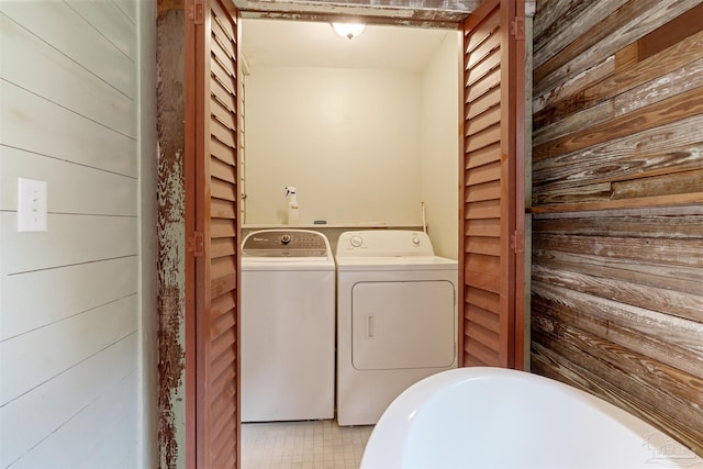 laundry room featuring washer and clothes dryer and wooden walls