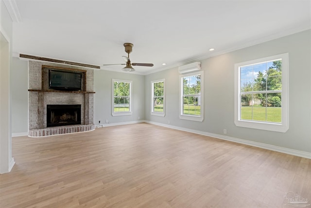 unfurnished living room featuring a fireplace, light hardwood / wood-style flooring, ornamental molding, and a wall mounted AC