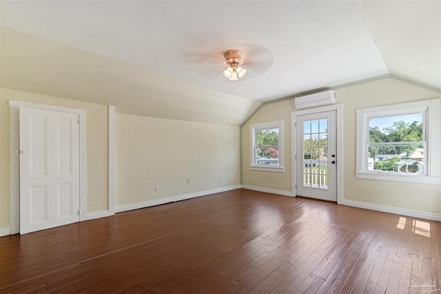 bonus room featuring dark hardwood / wood-style flooring, vaulted ceiling, and a wall unit AC