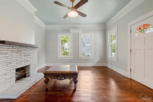 entrance foyer featuring wood-type flooring, ornamental molding, ceiling fan, and a fireplace