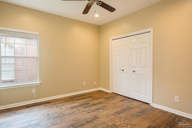 unfurnished bedroom featuring hardwood / wood-style floors, ceiling fan, and a closet