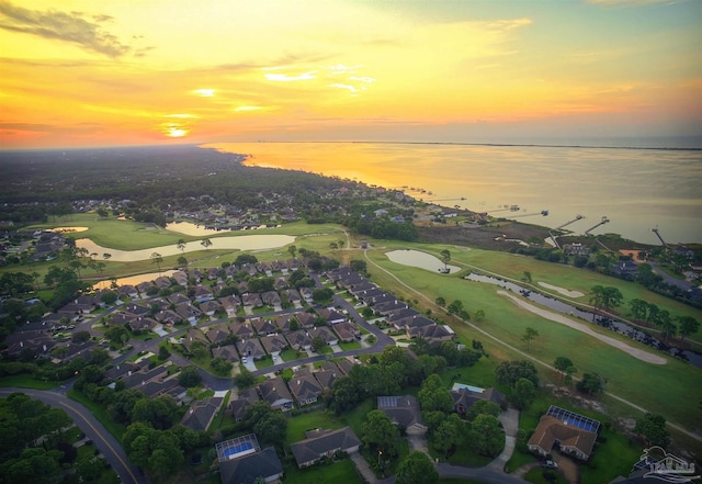 aerial view at dusk featuring a water view