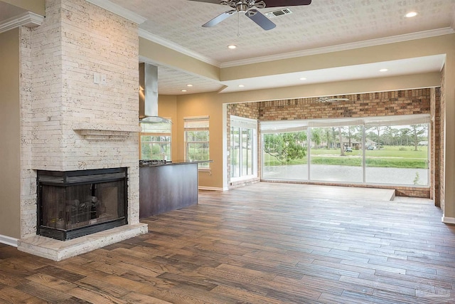 unfurnished living room featuring dark hardwood / wood-style floors, a fireplace, crown molding, and ceiling fan