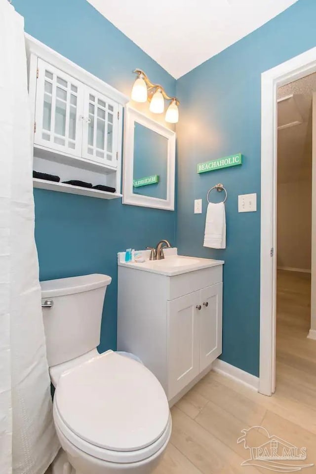 bathroom with hardwood / wood-style flooring, toilet, and vanity