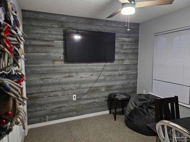 interior space featuring a textured ceiling, ceiling fan, and wooden walls