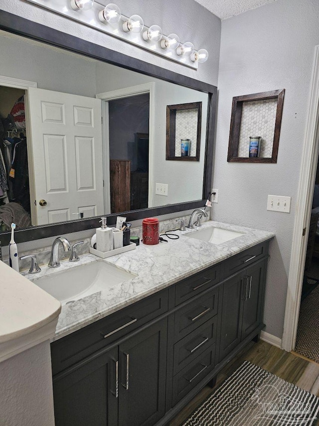 bathroom with a textured ceiling, hardwood / wood-style floors, and vanity