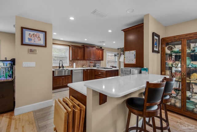 kitchen with a wealth of natural light, sink, a breakfast bar area, and kitchen peninsula