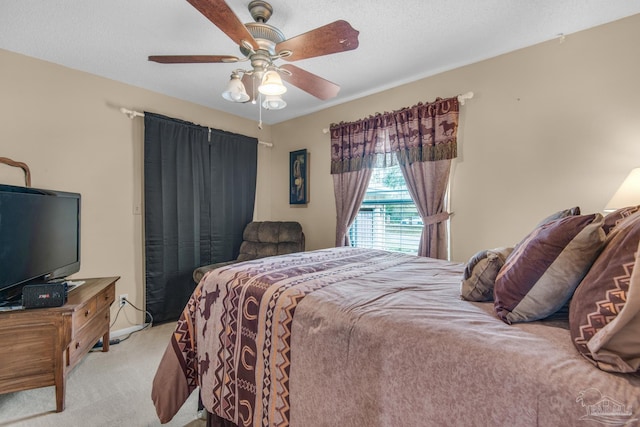 bedroom featuring light colored carpet, a textured ceiling, and ceiling fan