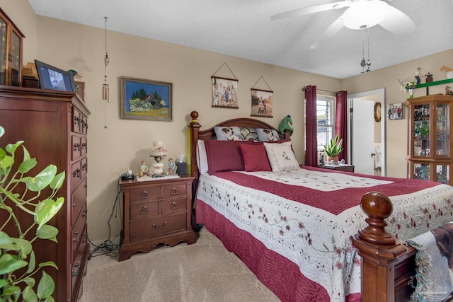 bedroom featuring ceiling fan, light colored carpet, and a textured ceiling