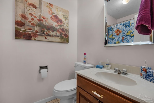 bathroom featuring vanity, a textured ceiling, tile patterned floors, and toilet