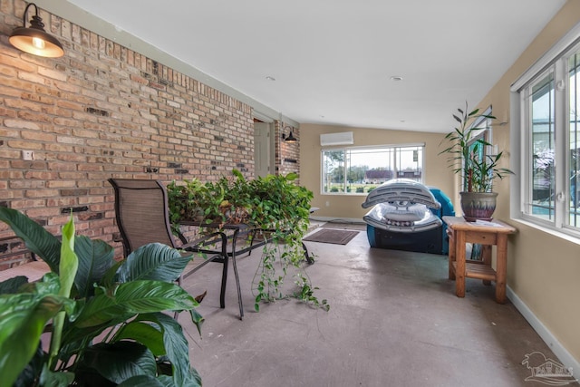 sunroom with lofted ceiling and a wall mounted AC