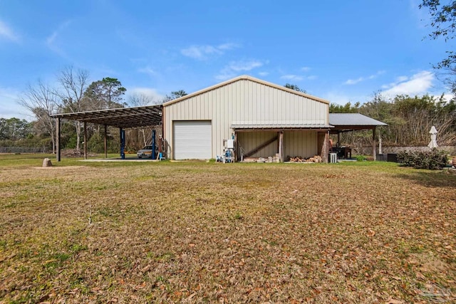 garage with a carport and a lawn