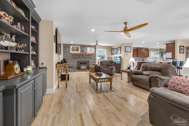 living room featuring plenty of natural light, ceiling fan, and light hardwood / wood-style flooring