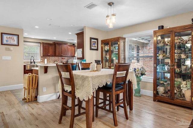 dining space with sink and light wood-type flooring