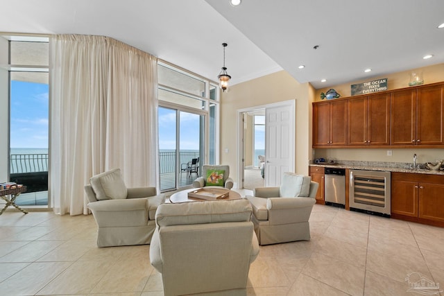 living room featuring light tile patterned floors, a water view, wine cooler, and crown molding