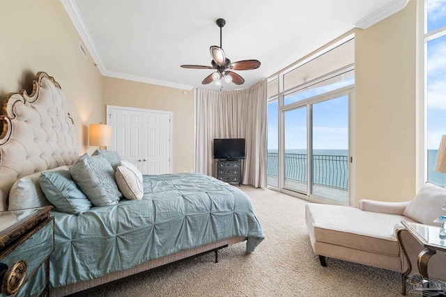 carpeted bedroom featuring access to exterior, ceiling fan, a wall of windows, a closet, and ornamental molding