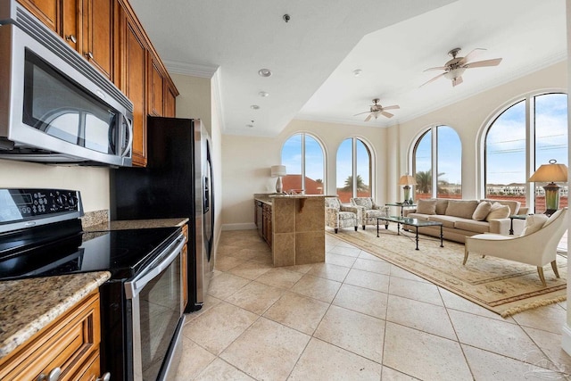 kitchen featuring a healthy amount of sunlight, light stone countertops, ornamental molding, and appliances with stainless steel finishes