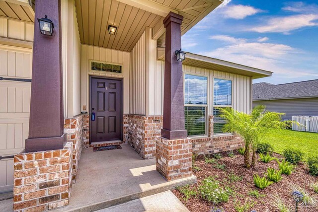 6319 Red Pepper Dr, Gulf Breeze, FL 32563 - doorway to property featuring board and batten siding, a porch, brick siding, and fence