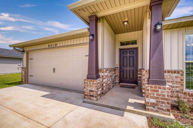 6319 Red Pepper Dr, Gulf Breeze, FL 32563 - property entrance with board and batten siding, stone siding, concrete driveway, and a garage