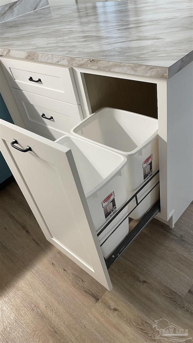 details with white cabinetry and hardwood / wood-style flooring