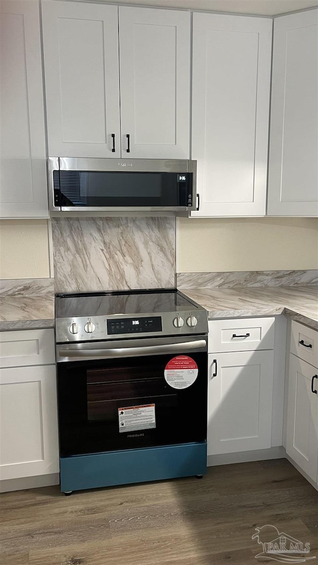 kitchen featuring white cabinets, light stone counters, and stainless steel appliances