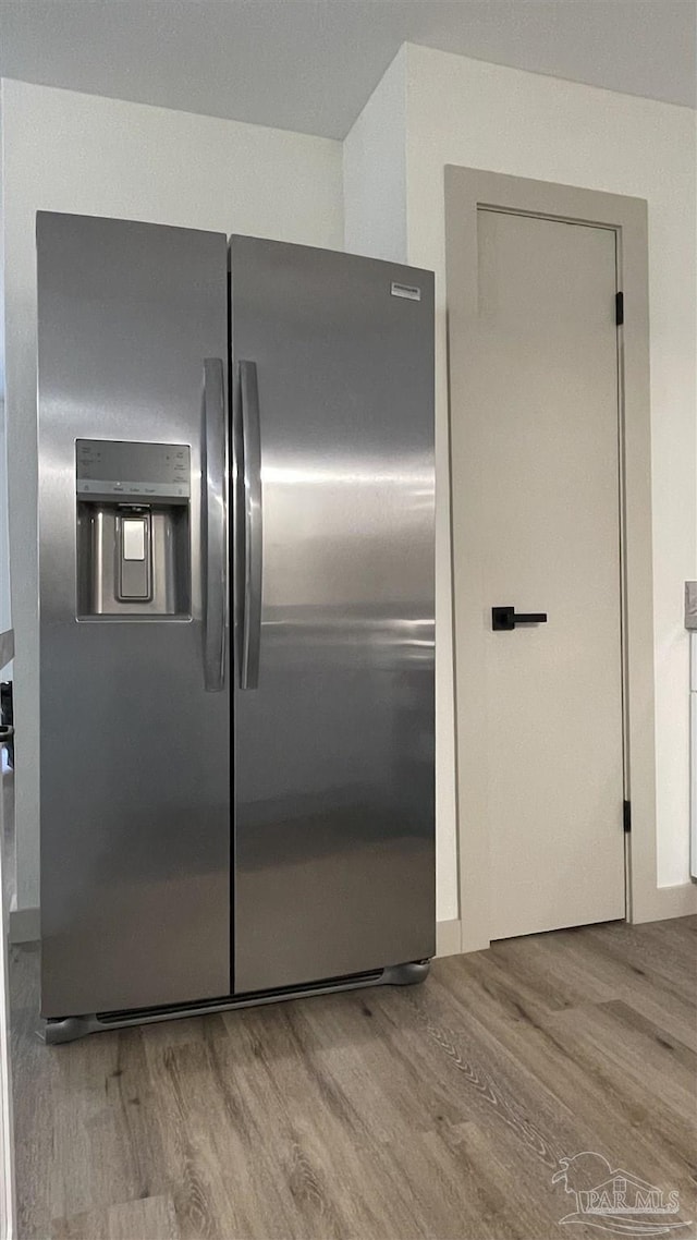 kitchen with stainless steel refrigerator with ice dispenser and light wood-type flooring