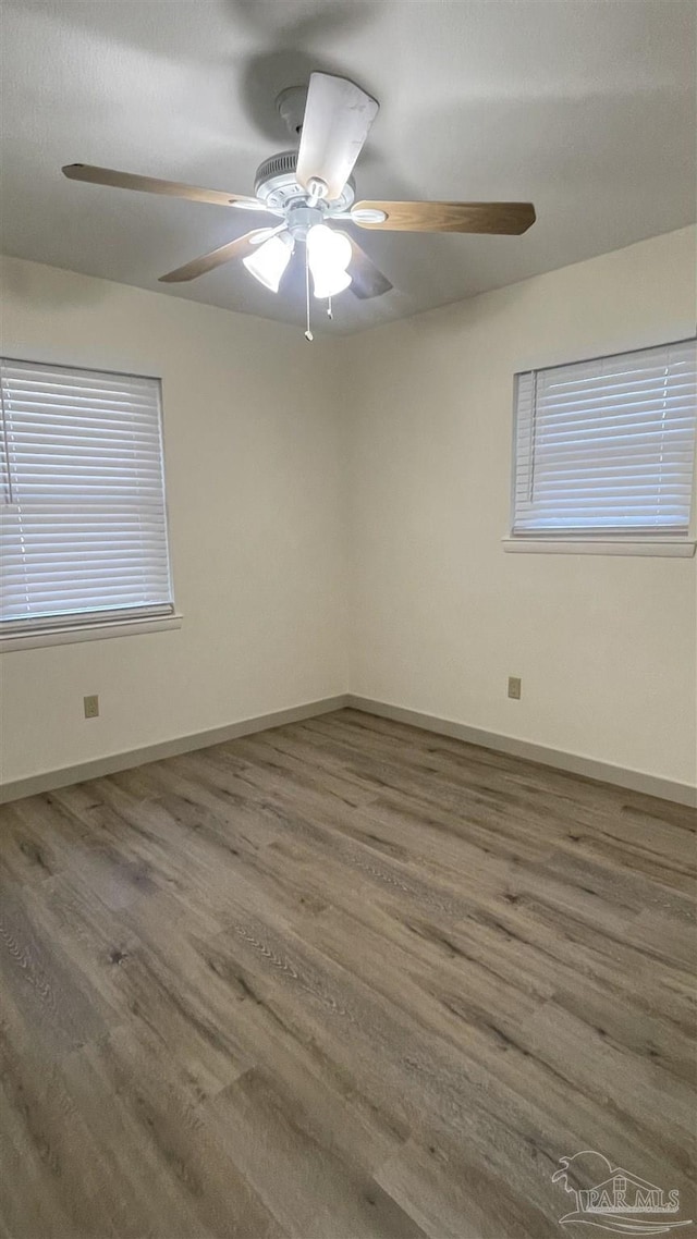 unfurnished room with ceiling fan and dark wood-type flooring