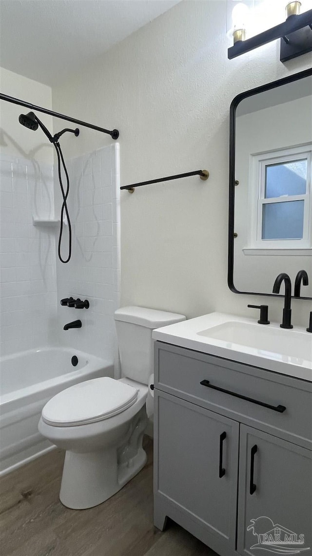 full bathroom featuring shower / bathing tub combination, wood finished floors, vanity, and toilet