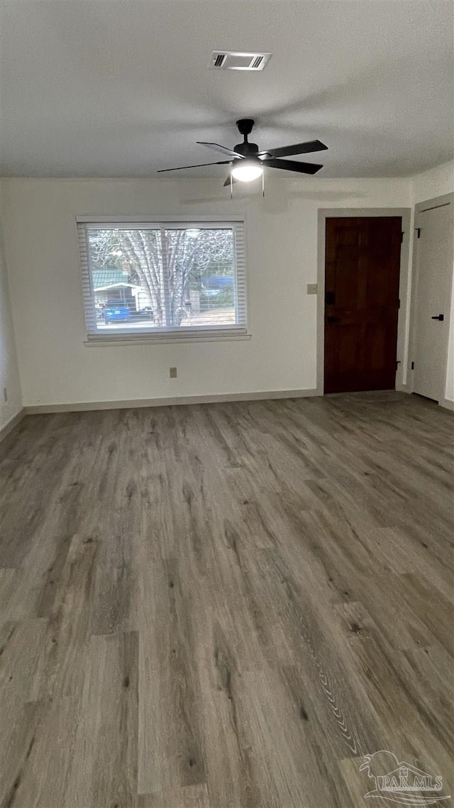 unfurnished room with hardwood / wood-style flooring and a textured ceiling