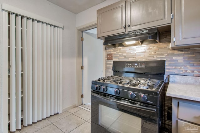 kitchen with black gas range, light tile patterned floors, and decorative backsplash