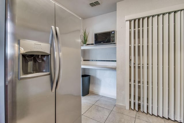 kitchen with stainless steel fridge and light tile patterned flooring