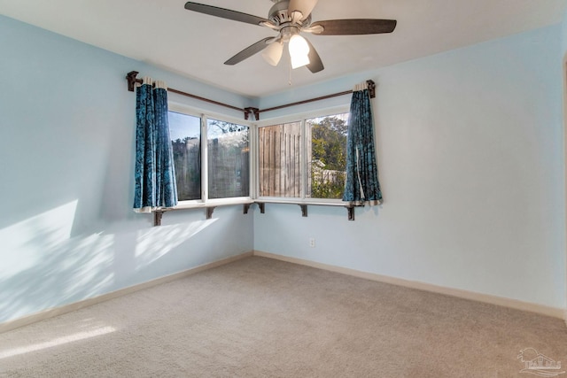 carpeted spare room featuring ceiling fan