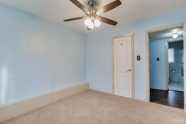 empty room with ceiling fan and light carpet