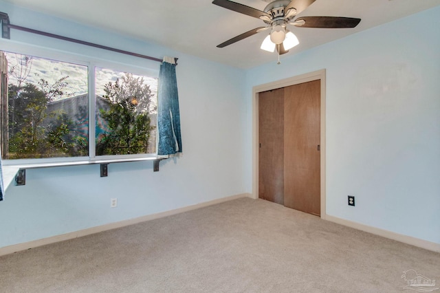 carpeted empty room featuring ceiling fan