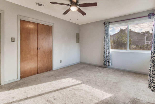 unfurnished bedroom with ceiling fan, light colored carpet, and a closet