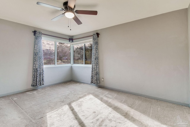 spare room with ceiling fan and light colored carpet