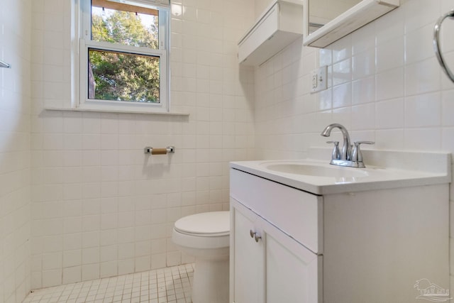 bathroom with toilet, tasteful backsplash, tile patterned flooring, tile walls, and vanity