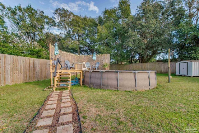 view of yard featuring a fenced in pool and a storage shed