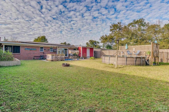 view of yard with a shed and a swimming pool side deck