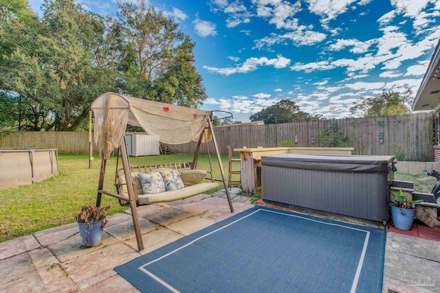 view of patio featuring a hot tub and a storage shed