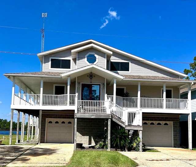 raised beach house featuring a garage and covered porch