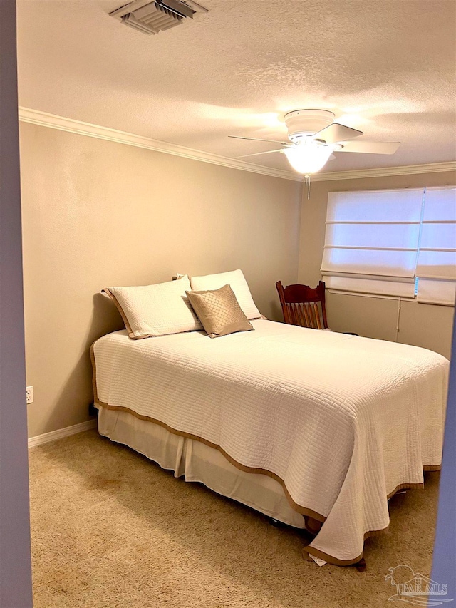 bedroom with ceiling fan, a textured ceiling, carpet flooring, and crown molding