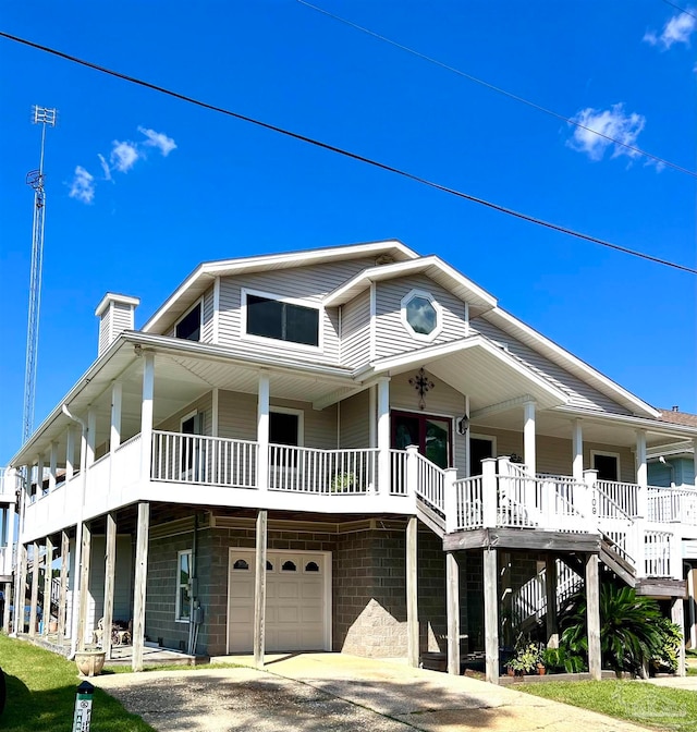 raised beach house with a garage and covered porch