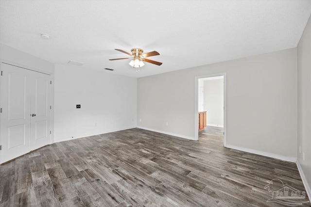 spare room featuring a textured ceiling, dark hardwood / wood-style floors, and ceiling fan