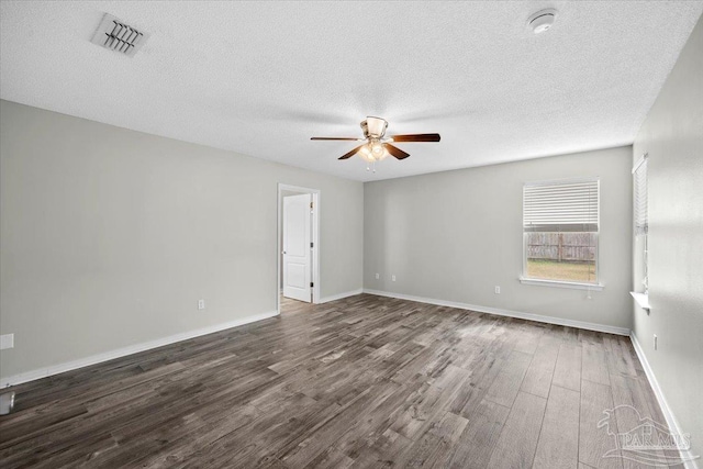 empty room with dark wood-type flooring, a textured ceiling, and ceiling fan