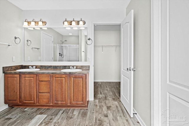 bathroom featuring hardwood / wood-style flooring, vanity, and a shower with door