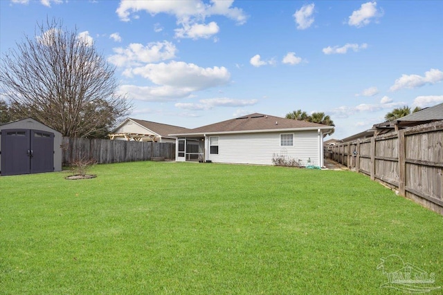 rear view of house featuring a lawn, a sunroom, and a storage unit